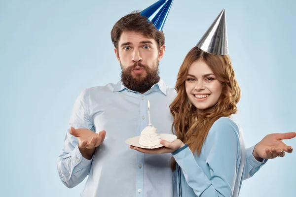 Kafalarında şapkaları olan neşeli adam ve kadın tatil eğlencesi mavi arka planı — Stok fotoğraf