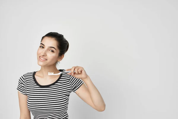 Morena em uma camiseta listrada escovando os dentes close-up — Fotografia de Stock