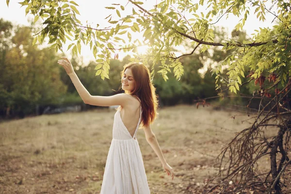 野原の屋外でポーズをとる白いドレスを着た陽気な女性 — ストック写真
