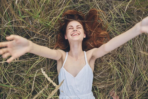 Veselá žena v poli leží na trávě úsměv dovolená léto — Stock fotografie