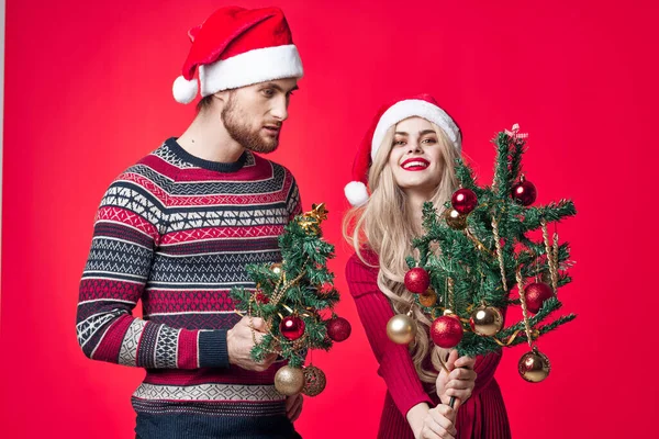 若いカップルの休日のクリスマスの装飾赤の背景 — ストック写真
