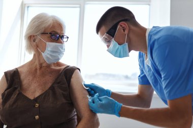 Doktorlar yaşlı bir kadına pasaport aşısı yaptılar.