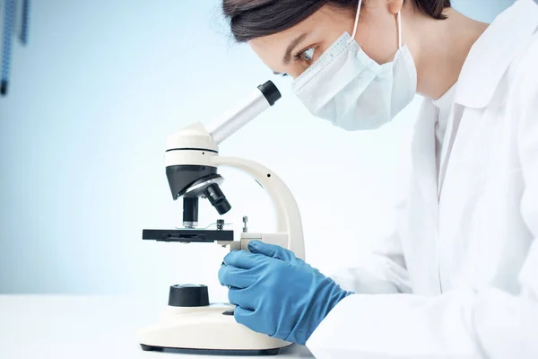 Asistente de laboratorio mujer mirando a través de un microscopio investigación ciencia medicina —  Fotos de Stock