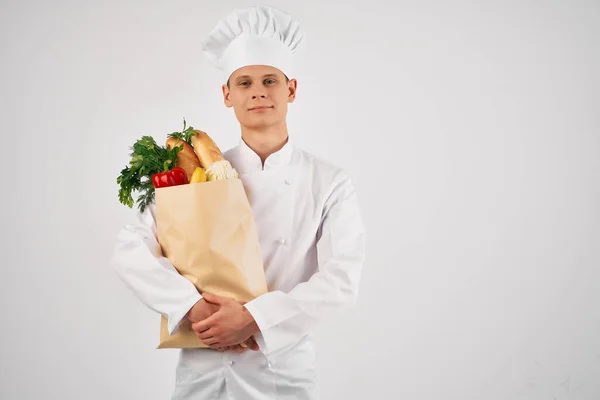 Chef maschio con un pacchetto di generi alimentari ristorante cucina professionale — Foto Stock