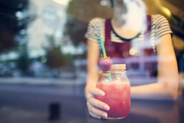 Een vrouw met een kort kapsel zit in een cafe alleen met een cocktail — Stockfoto