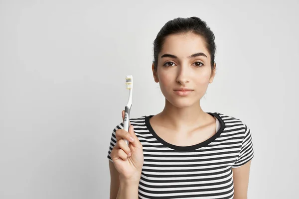 Mulher em listrado t-shirt escova de dentes estilo de vida higiene — Fotografia de Stock