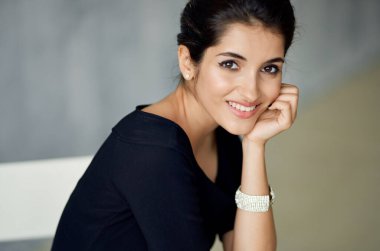 Siyah elbise stüdyosundaki neşeli kadın moda makyajı yapıyor.