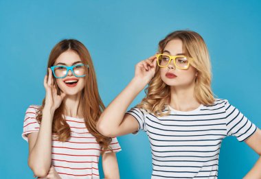 Çizgili tişörtlü iki neşeli kadın yaz stili mavi arka plan