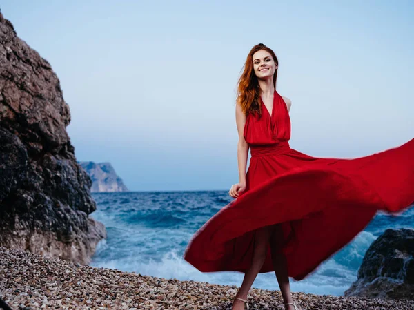 Γυναίκα Κόκκινο Φόρεμα Στην Ακτή Ποζάροντας — Φωτογραφία Αρχείου