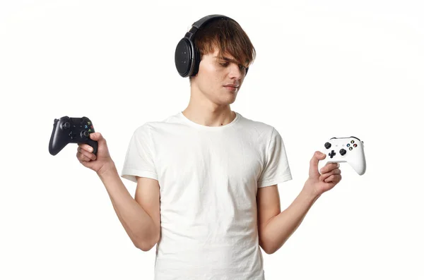 Man in een wit t-shirt in hoofdtelefoon met een joystick video games technologie gamer — Stockfoto