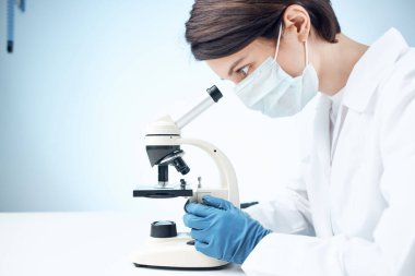 Laboratuvar asistanı mikroskop bilimsel araştırma teknolojisi deneyine bakıyor.