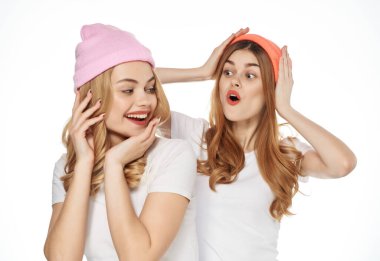 Beyaz tişörtlü komik kız arkadaşlar renkli şapkalar modern moda yakın çekim.