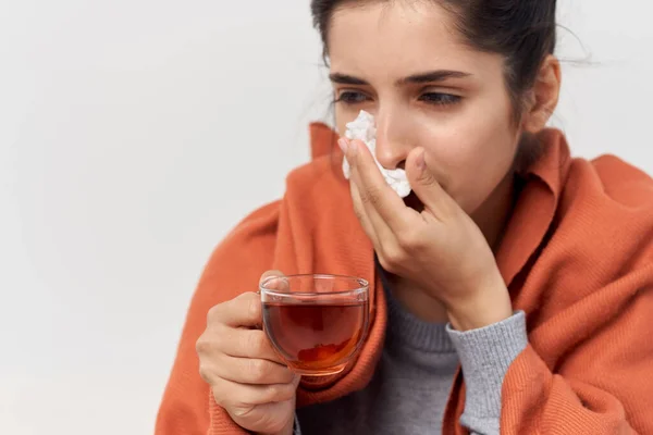 Lopen vrouw verschuilen achter een ruit thuis met een kopje thee ongezonde blik — Stockfoto