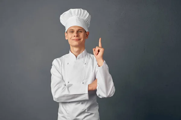 Homem alegre em uniforme de chefs levanta a mão Restaurante gourmet — Fotografia de Stock