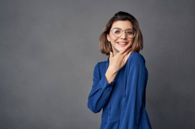 Mavi gömlekli kadın cazibe pozu veriyor.