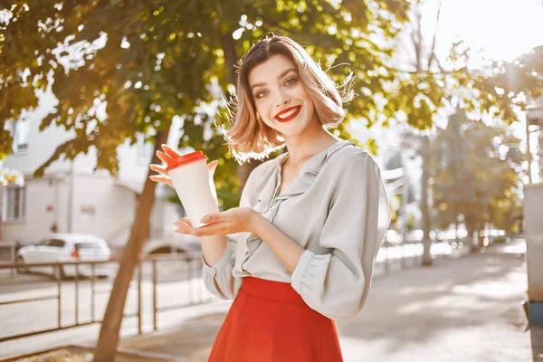 Весела жінка з чашкою кави на відкритому повітрі влітку — стокове фото