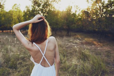 Beyaz elbiseli güzel kadın doğa ağaçlarında özgürdür.