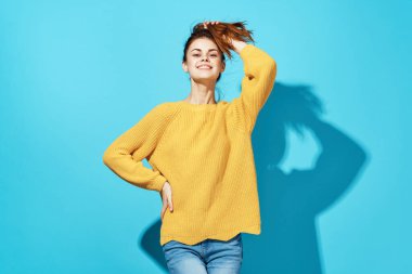 Sarı kazaklı kadın moda stüdyosunda poz veriyor.