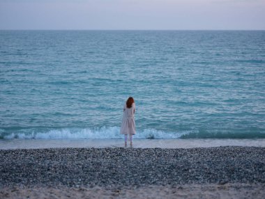 Kadınlar kıyı boyunca yürür. Okyanus manzarası tatil akşamları romantizm.