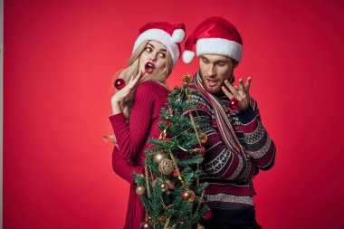 Elinde Noel ağacı olan bir kadın. Yanında da bayram ailesi olan bir erkek.