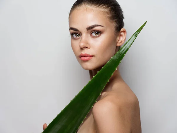 Nude woman with aloe leaf on a light background side view Copy Space — Stock Photo, Image