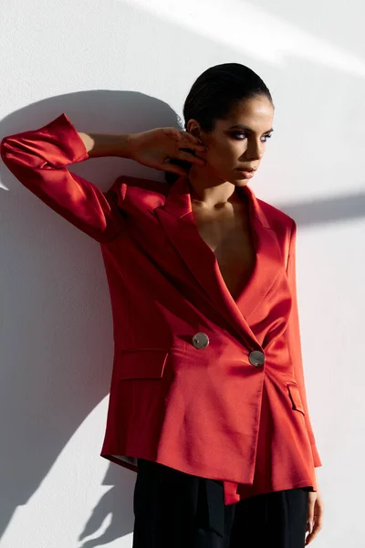 Mulher confiante em jaqueta vermelha fica perto da parede interior quarto terno estilo de moda — Fotografia de Stock