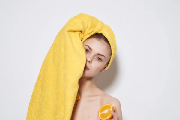 Mulher com toalha amarela na cabeça ombros nus fruta laranja vitamina — Fotografia de Stock