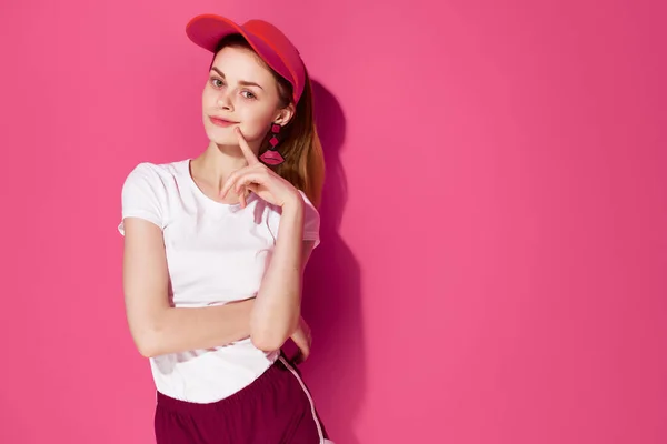 Vidám nő piros sapkában nyári divat ruhák pózol rózsaszín háttér — Stock Fotó