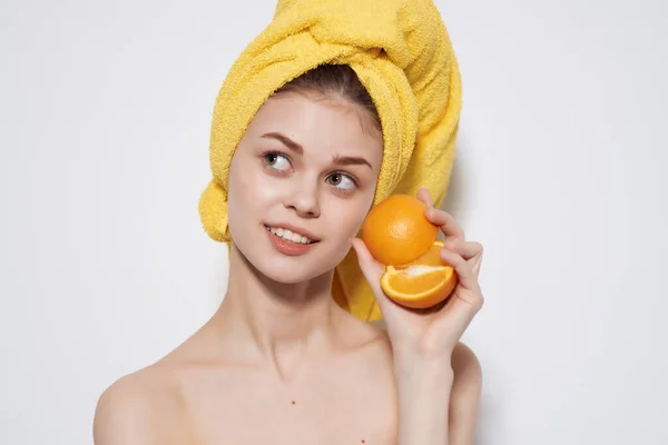 Mulher com toalha amarela na cabeça ombros nus fruta laranja vitamina — Fotografia de Stock