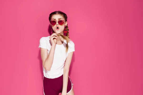 Gaie femme à la mode portant des lunettes de soleil vêtements d'été fond rose — Photo