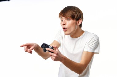 Elinde joystick olan beyaz tişörtlü bir adam eğlence teknolojisi oynuyor.