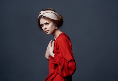 Kırmızı elbiseli kadın ve mücevher duyguları koyu arka planda.