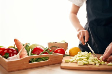 Tahtadaki sebzeleri kesmek, sağlıklı yemek pişirmek.