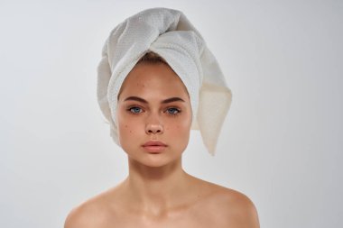 Kafasında havlu olan bir kadın çıplak omuzlarıyla yakın plan temiz ciltli.