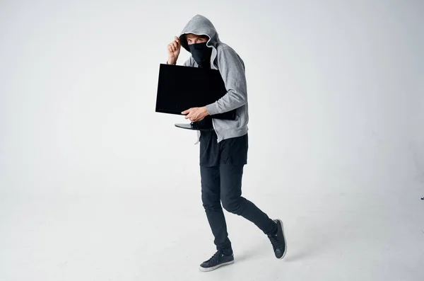 Mężczyzna w masce złodziej z monitorem w rękach zbrodnia — Zdjęcie stockowe