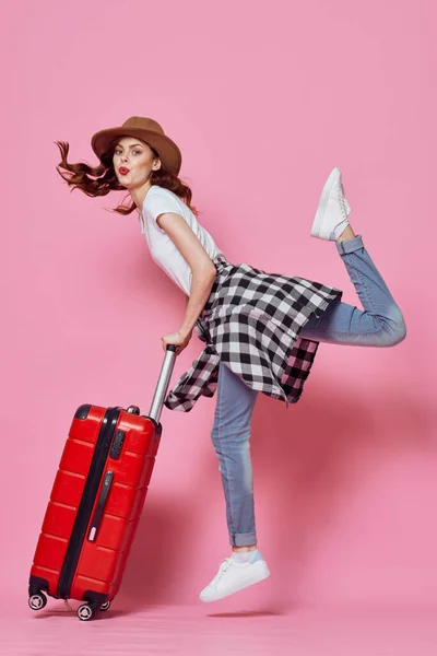 Allegra donna con valigia bagagli viaggio intrattenimento rosa sfondo — Foto Stock
