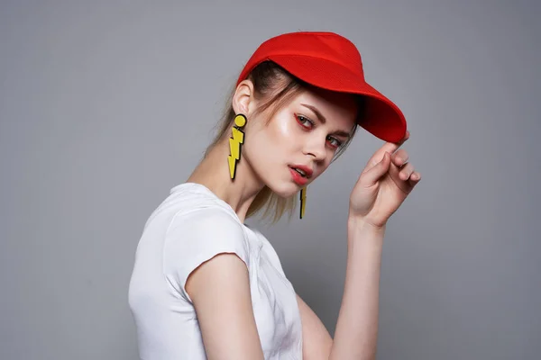 Дівчина в червоній шапці жовті сережки стиль життя аксесуари літній стиль — стокове фото