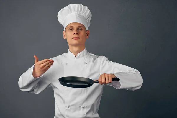 Glada kock i uniform stekpanna i händerna på restaurang matlagning — Stockfoto