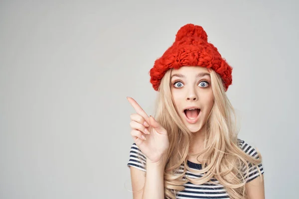 Χαρούμενη ξανθιά με κόκκινο καπέλο, να κάνει χειρονομίες με τα χέρια της. — Φωτογραφία Αρχείου