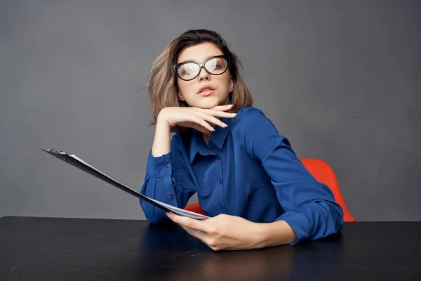 Kobieta w niebieskiej koszuli siedzi przy stole folderu w rękach Kopiuj przestrzeń — Zdjęcie stockowe