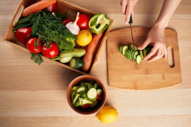 Kesme tahtasında taze sebze kesmek evde sağlıklı yemek.