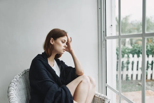 Ledsen kvinna sitter nära fönstret ensamhet njutning — Stockfoto