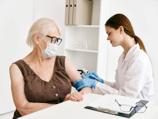 Medico che somministra un'iniezione ad una donna anziana vaccino passaporto immunità protezione — Foto Stock