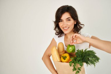 Beyaz tişörtlü kadın paketinde sağlıklı yiyecek teslimatı süpermarketi