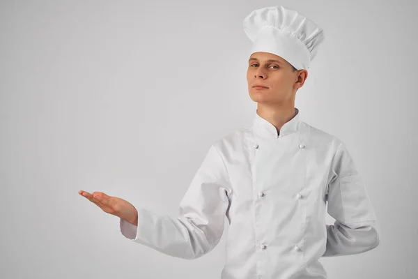 Un uomo in uniforme chef gesticolando con il suo lavoro a mano cucina professionale — Foto Stock