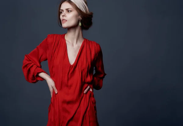 Mulher em vestido vermelho headband posando estilo elegante fundo escuro — Fotografia de Stock