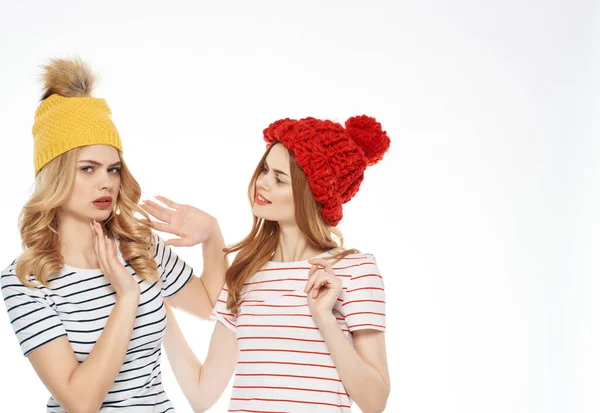 Φιλενάδες στέκονται δίπλα σε ριγέ πουκάμισα πολύχρωμα καπέλα μόδας — Φωτογραφία Αρχείου