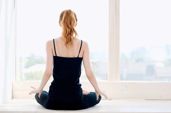 Mujer cerca de la ventana yoga rendimiento meditación flexibilidad — Foto de Stock