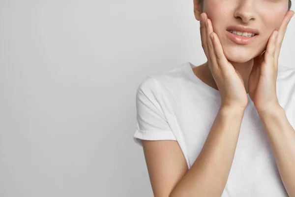 Mulher de t-shirt branca segurando dor de rosto nos dentes problemas de saúde odontologia — Fotografia de Stock