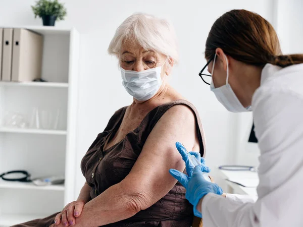 Sjuksköterska som ger en injektion till patienten skuldra covid-19 vaccinationspass — Stockfoto